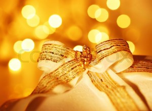 3054434-gold-holiday-background-with-white-present-gift-box-christmas-ornament-and-new-year-decoration-over-abstract-defocused-lights