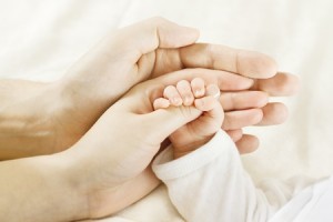 12374467 - closeup of baby hand into parents hands. family concept